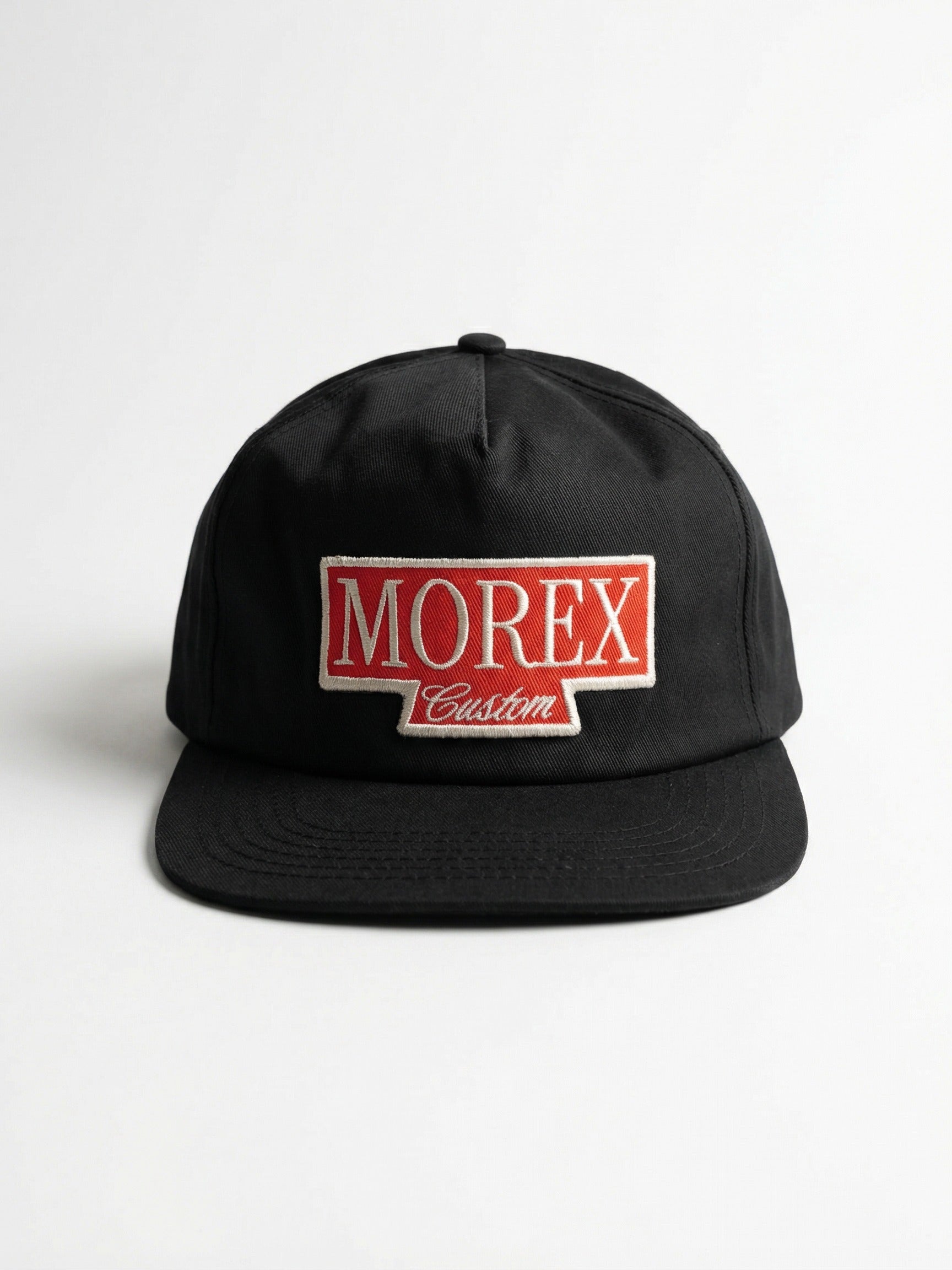 Casquette noire Morex Custom avec un patch brodé rouge et blanc sur le devant, style vintage moto et lifestyle.