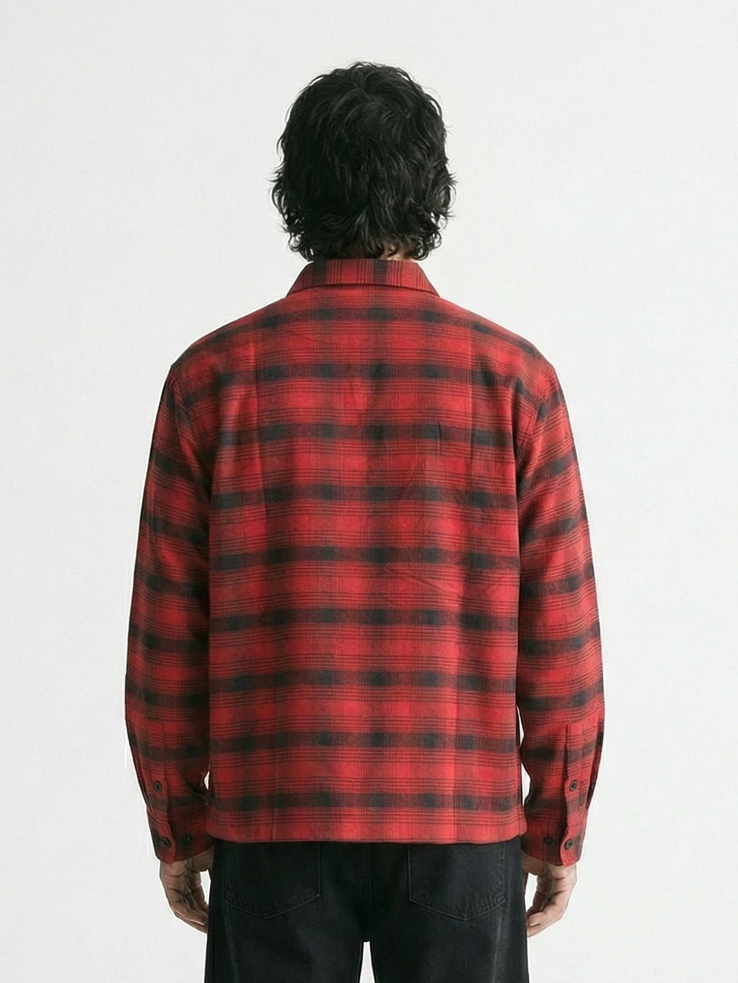 Vue de dos d'un homme portant une chemise en flanelle à carreaux rouge et noir Morex Custom avec un pantalon noir.