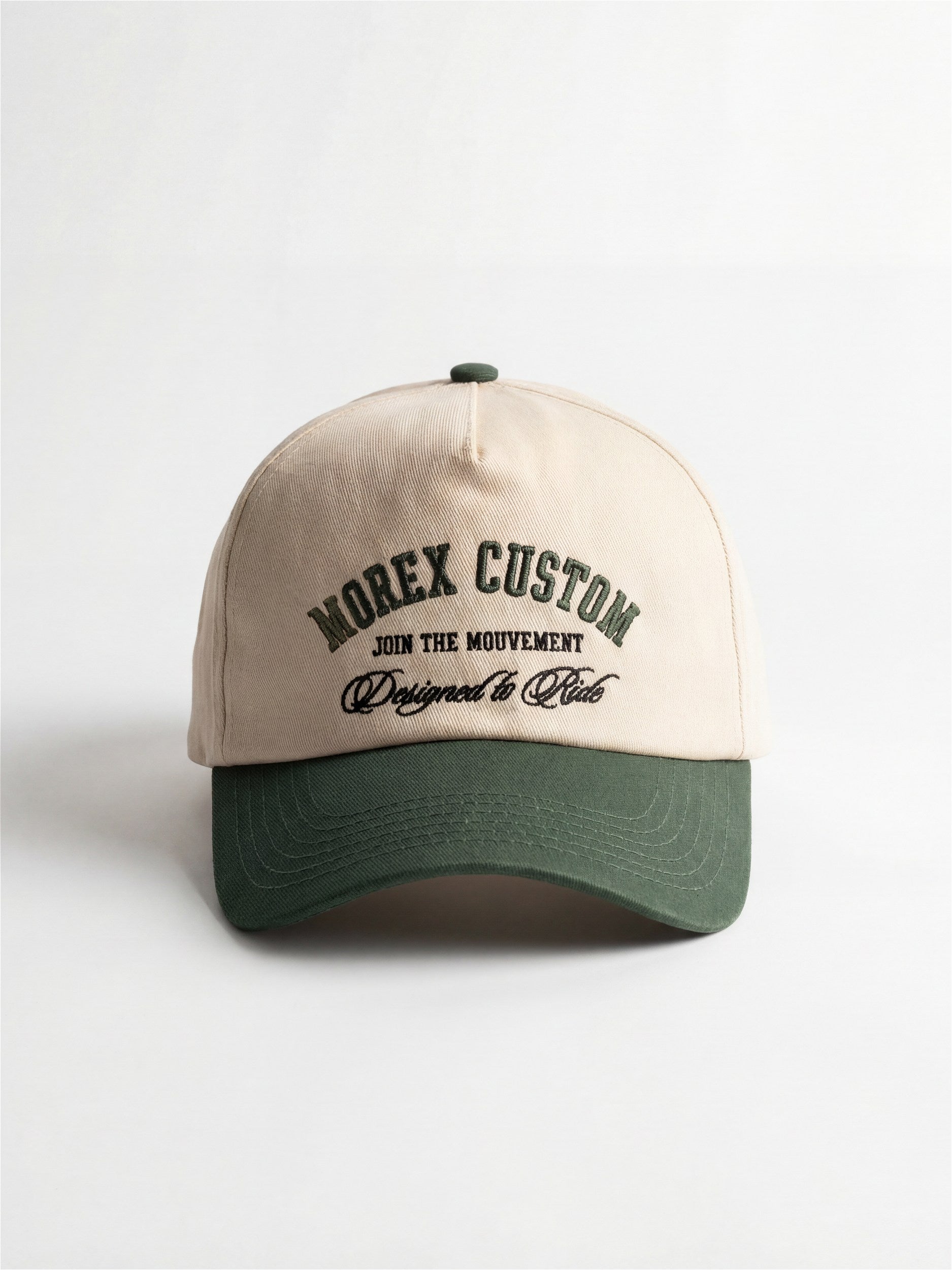 A two-tone baseball cap featuring a beige crown and a dark green brim with 'MOREX CUSTOM' embroidered on the front.