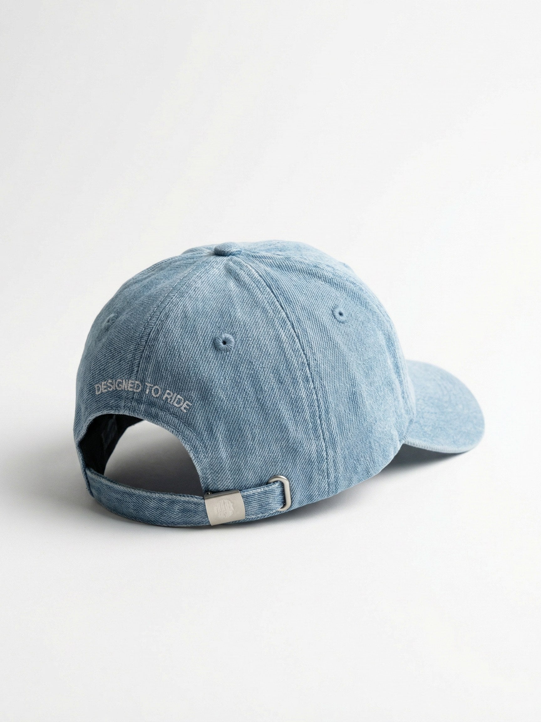 Vue arrière d'une casquette Morex Custom en denim bleu clair avec l'inscription brodée 'Designed to Ride' et une lanière ajustable.