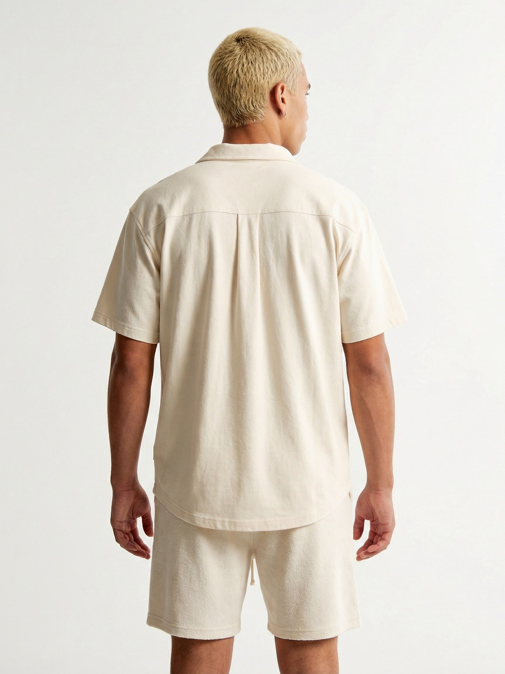 Vue de dos d'un homme portant un ensemble Morex Custom composé d'une chemise à manches courtes et d'un short assorti de couleur beige crème.