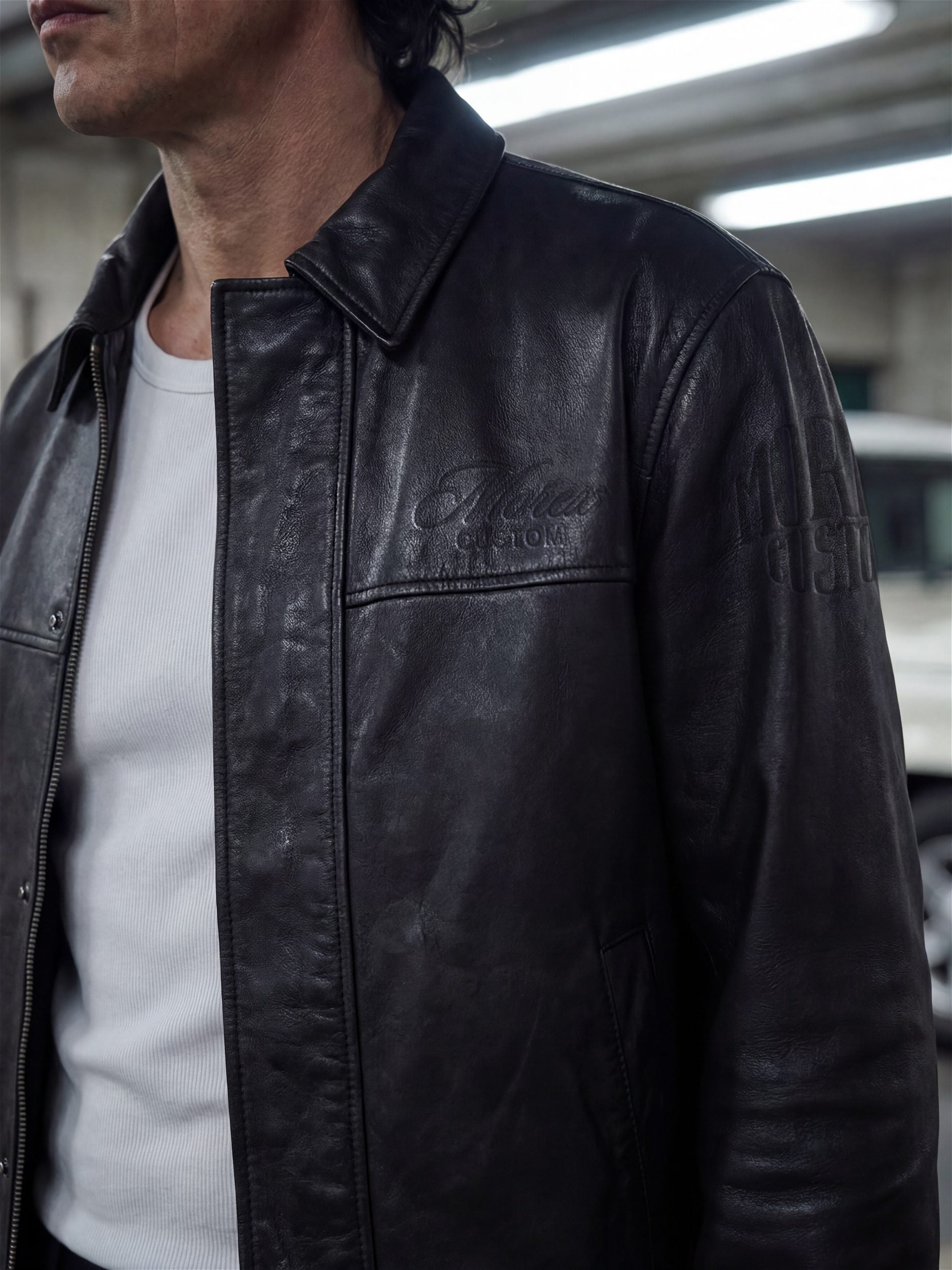 Gros plan d'une veste en cuir noir vieilli pour homme de la marque Morex Custom, style moto et lifestyle vintage avec logo embossé.