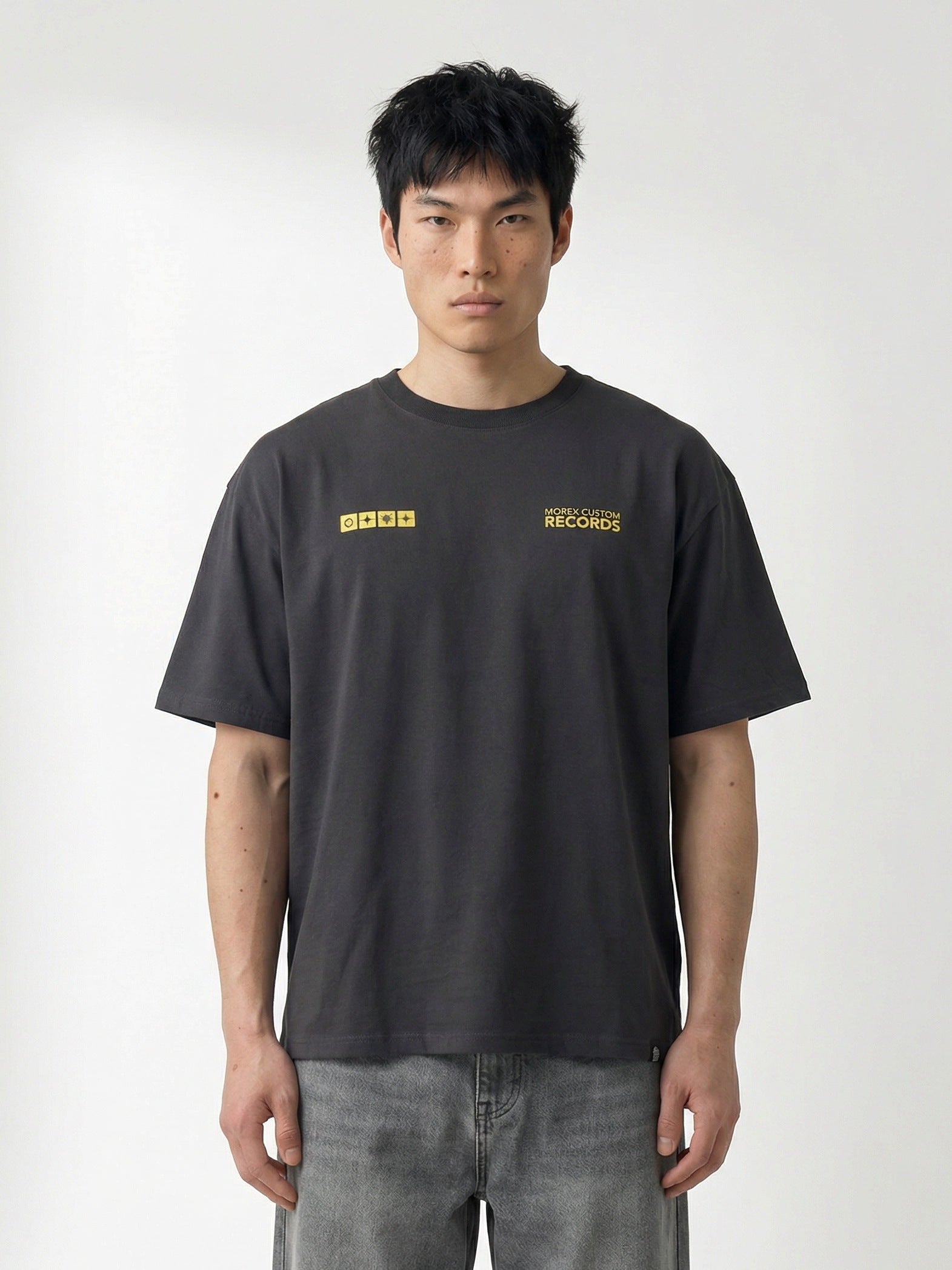 Homme portant un t-shirt Morex Custom gris anthracite avec logos jaunes sur la poitrine, style lifestyle et moto.