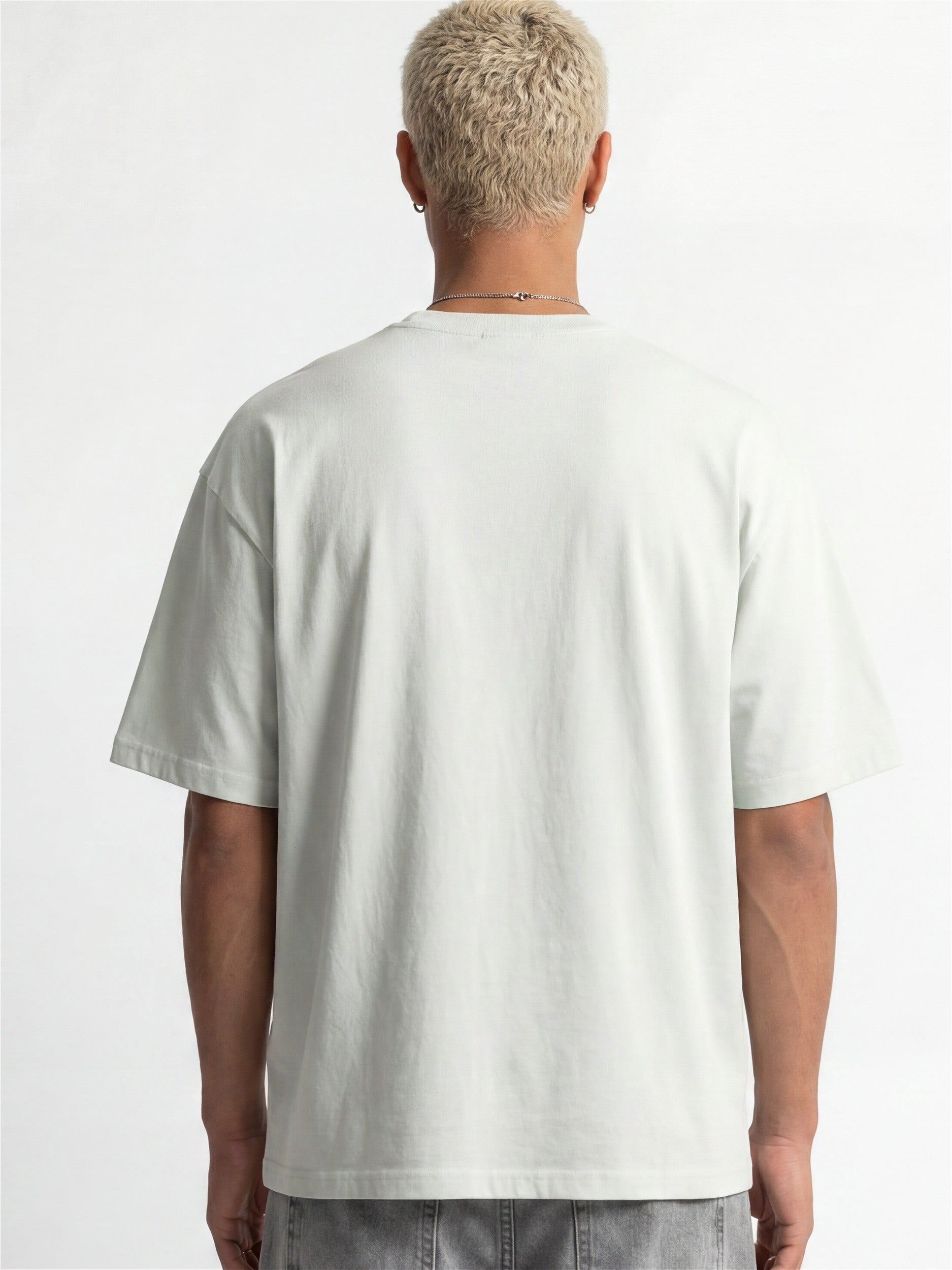 Vue de dos d'un homme portant un t-shirt Morex Custom gris clair de style lifestyle moto, associé à un jean gris.
