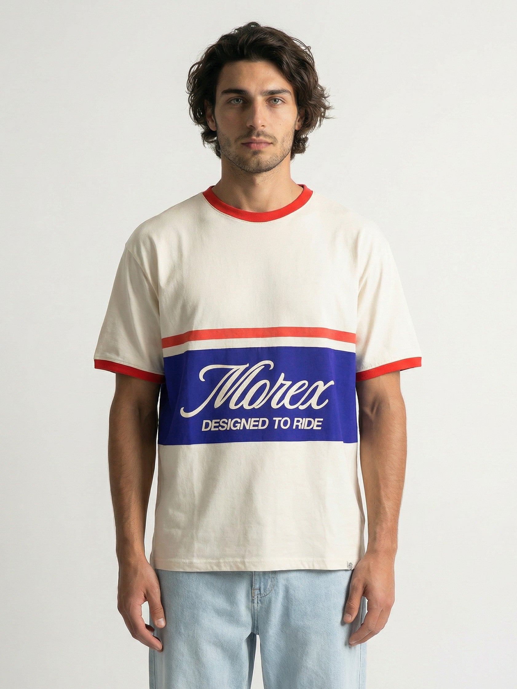 Homme portant un t-shirt Morex Custom de couleur crème avec un col ringer rouge et une large bande bleue sur le torse affichant le logo Morex et le slogan Designed to Ride.