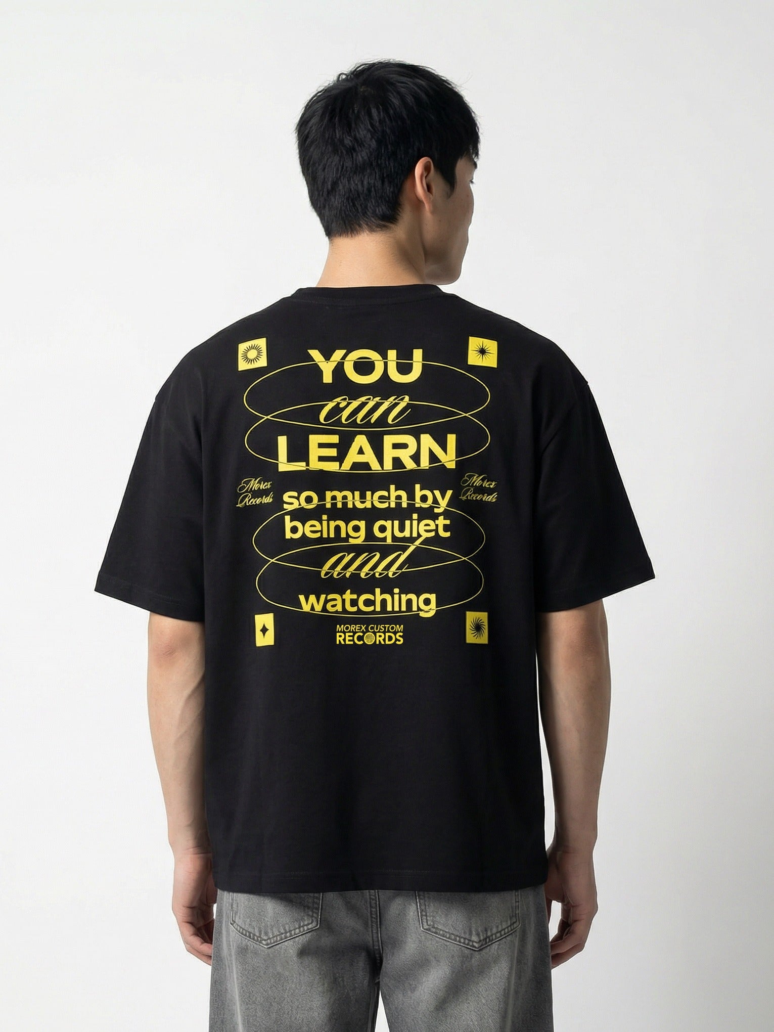 T-shirt noir Morex Custom pour homme avec une citation graphique jaune au dos : 'YOU CAN LEARN so much by being quiet and watching'.