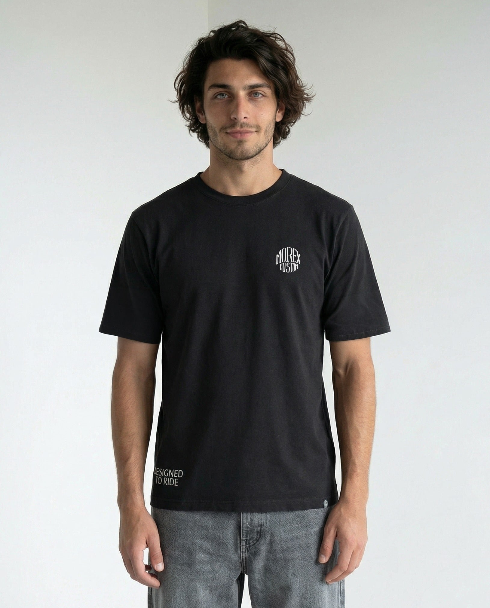 Homme portant un t-shirt noir Morex Custom avec petit logo blanc sur la poitrine, style casual et moto.