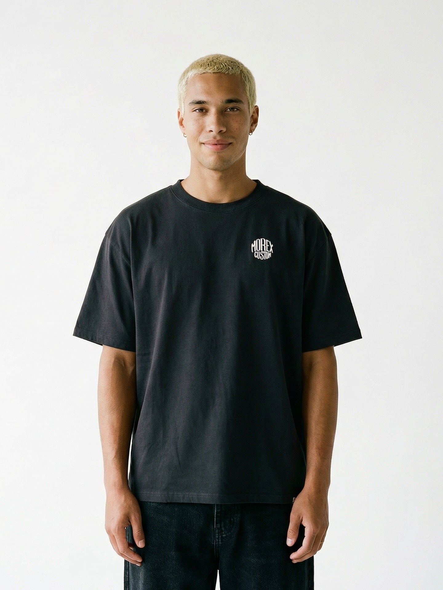 Tee-shirt noir Morex Custom avec petit logo blanc sur la poitrine, style lifestyle et vintage, vue de face sur un homme.