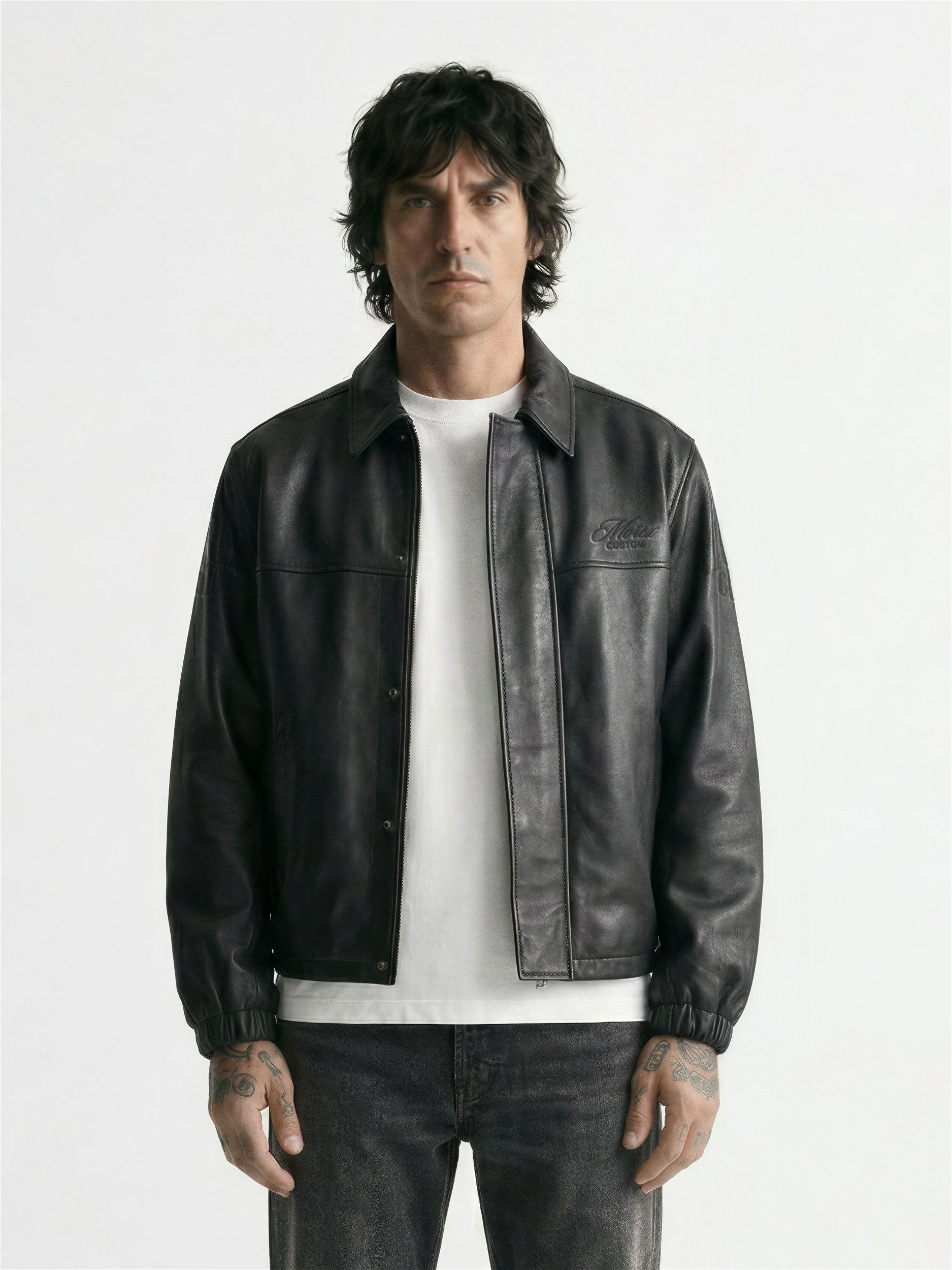 Homme portant un blouson en cuir noir Morex Custom avec un t-shirt blanc et un jean gris délavé, look urbain et lifestyle moto.