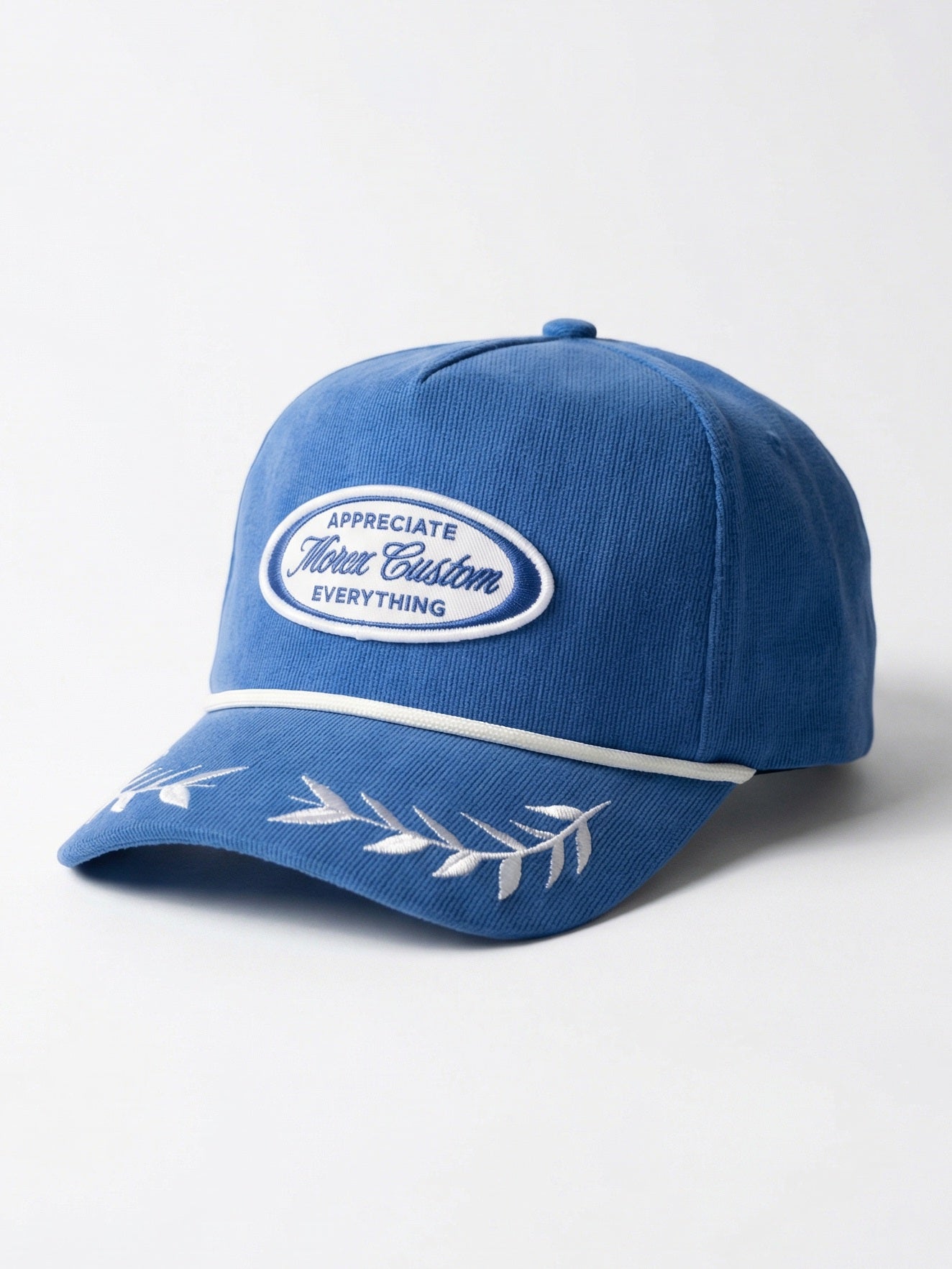 Casquette bleue de la marque Morex Custom avec un patch ovale brodé et des motifs de feuilles sur la visière.
