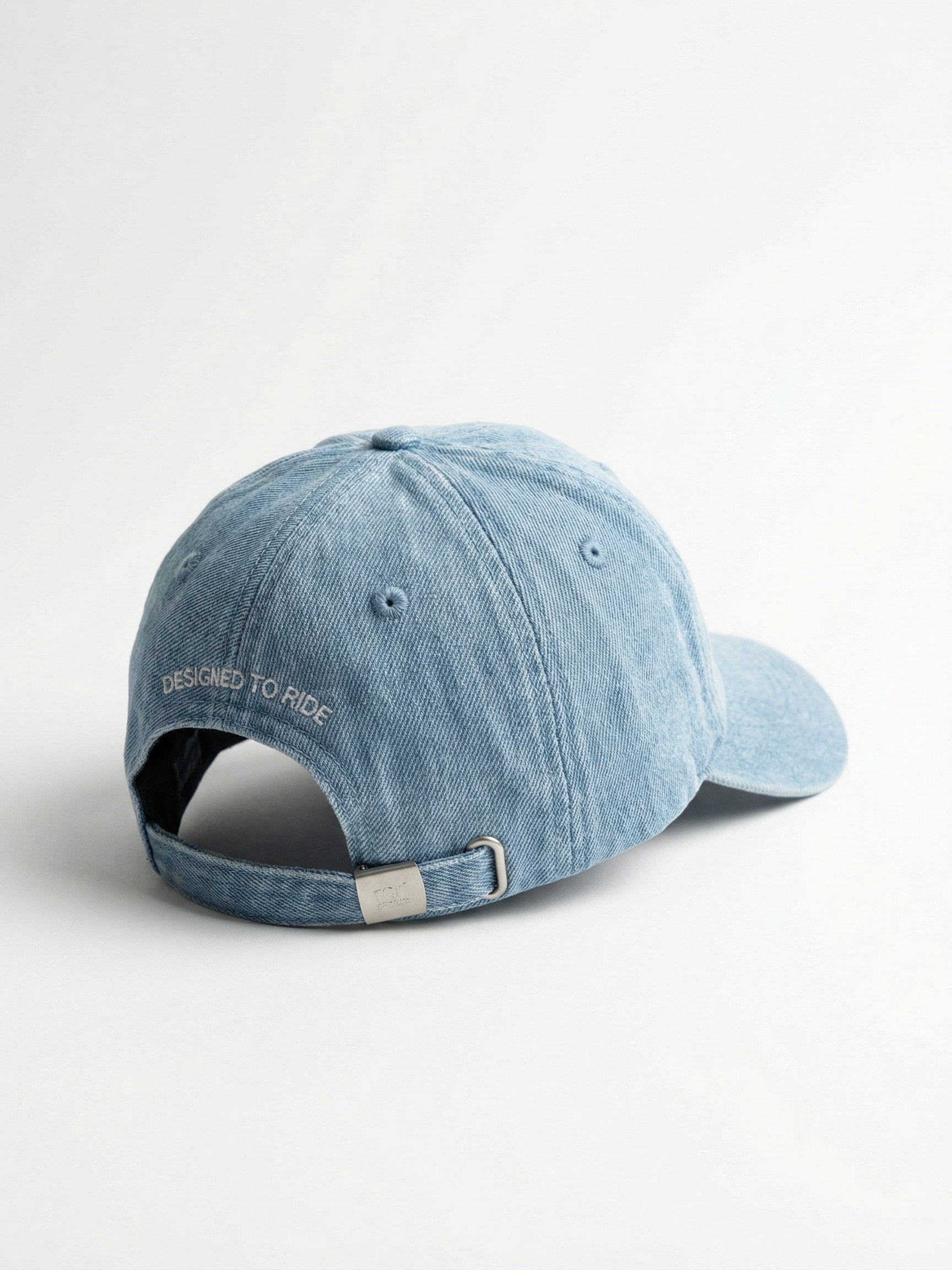 Vue arrière d'une casquette Morex Custom bleue avec la broderie 'Designed to ride' au-dessus de la fermeture réglable.