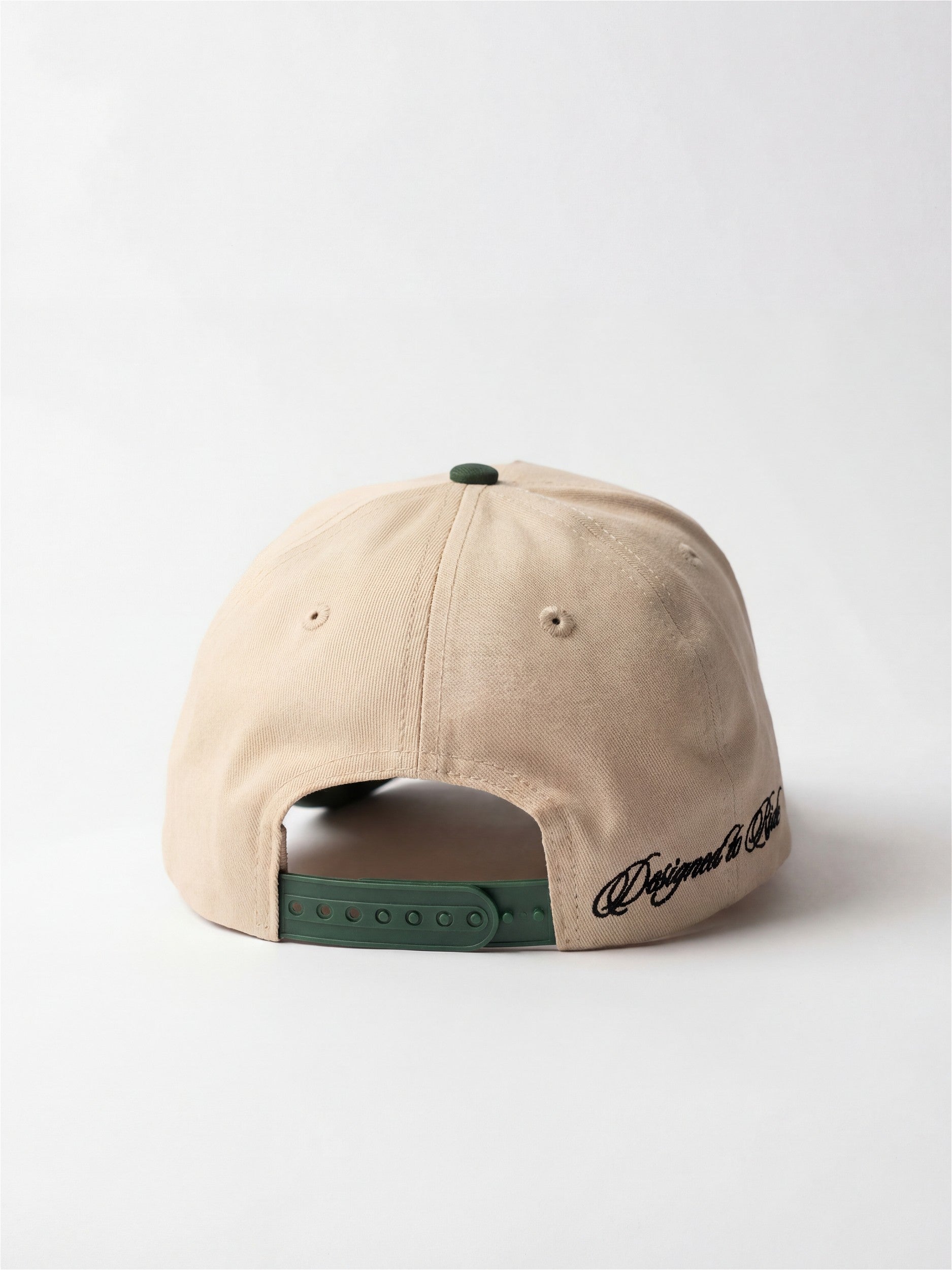 Vue arrière d'une casquette snapback Morex Custom de couleur beige avec une attache verte et la broderie Designed in Biarritz sur le côté.