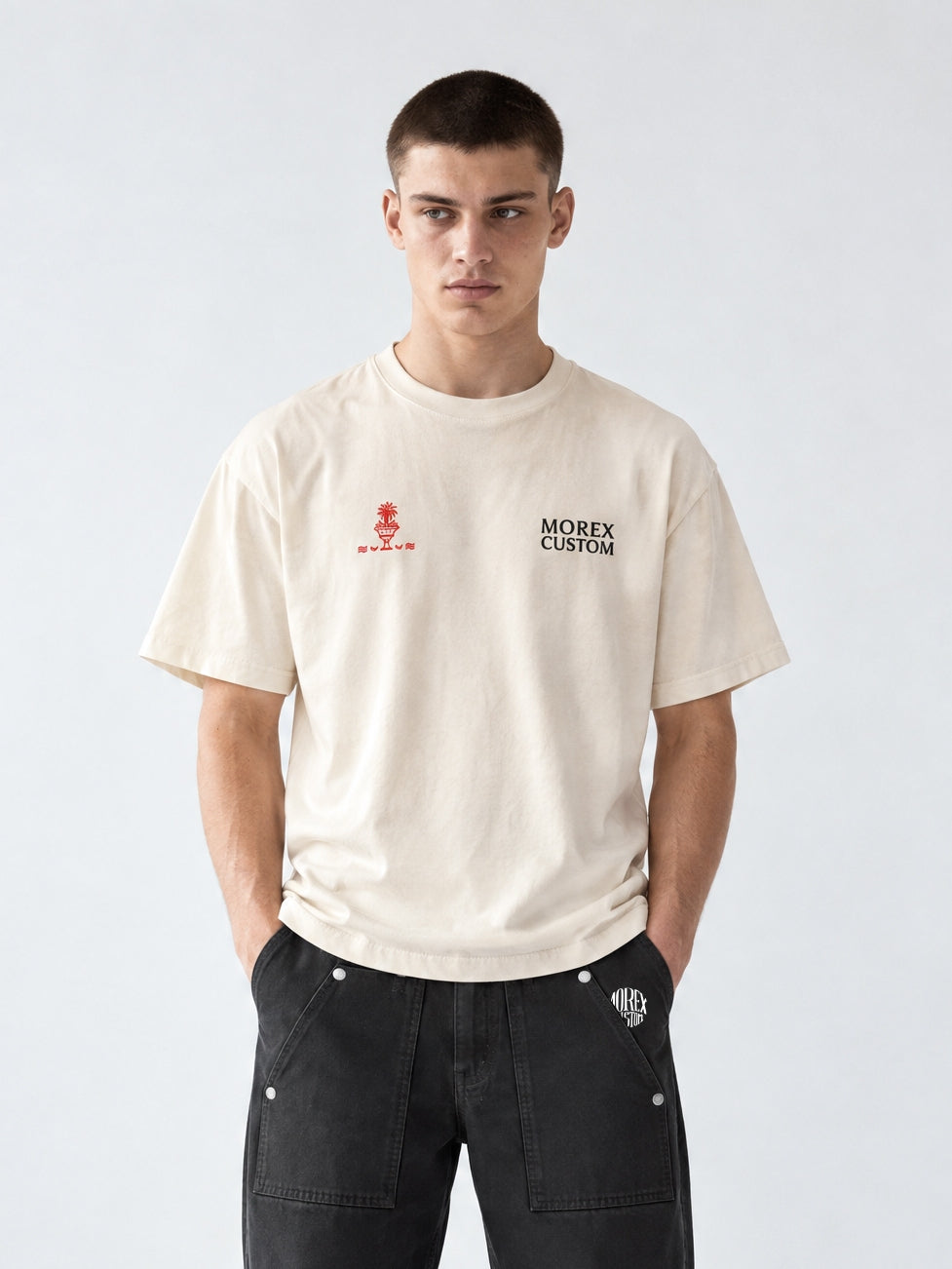 Homme portant un t-shirt oversize écru Morex Custom et un pantalon workwear noir ample, look lifestyle moto et urbain.