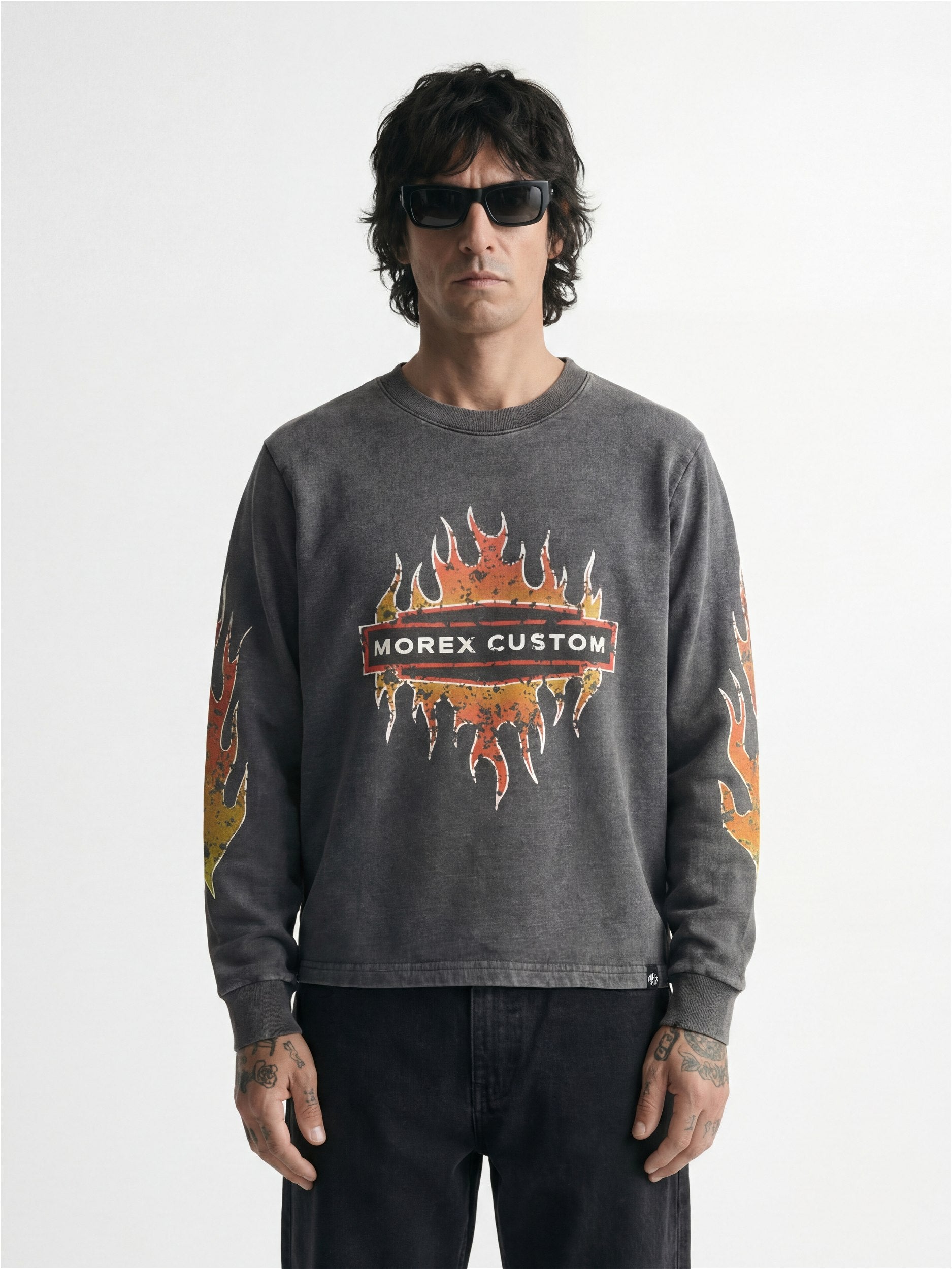 Homme portant un sweat-shirt Morex Custom gris délavé avec logo central et motifs de flammes sur la poitrine et les manches.