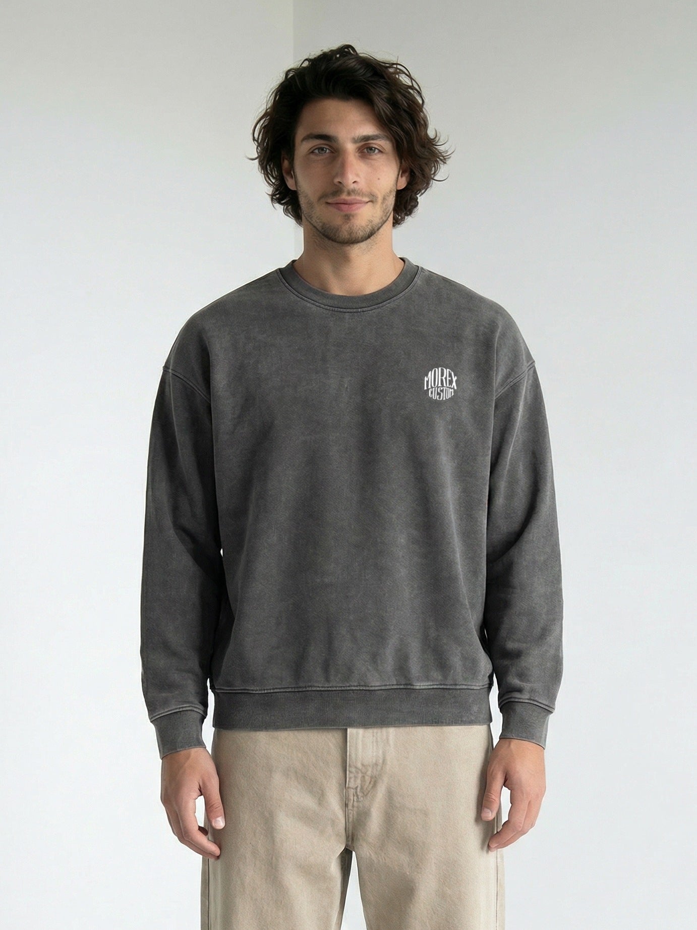 Homme portant un sweatshirt Morex Custom gris anthracite délavé avec un petit logo blanc circulaire sur la poitrine.