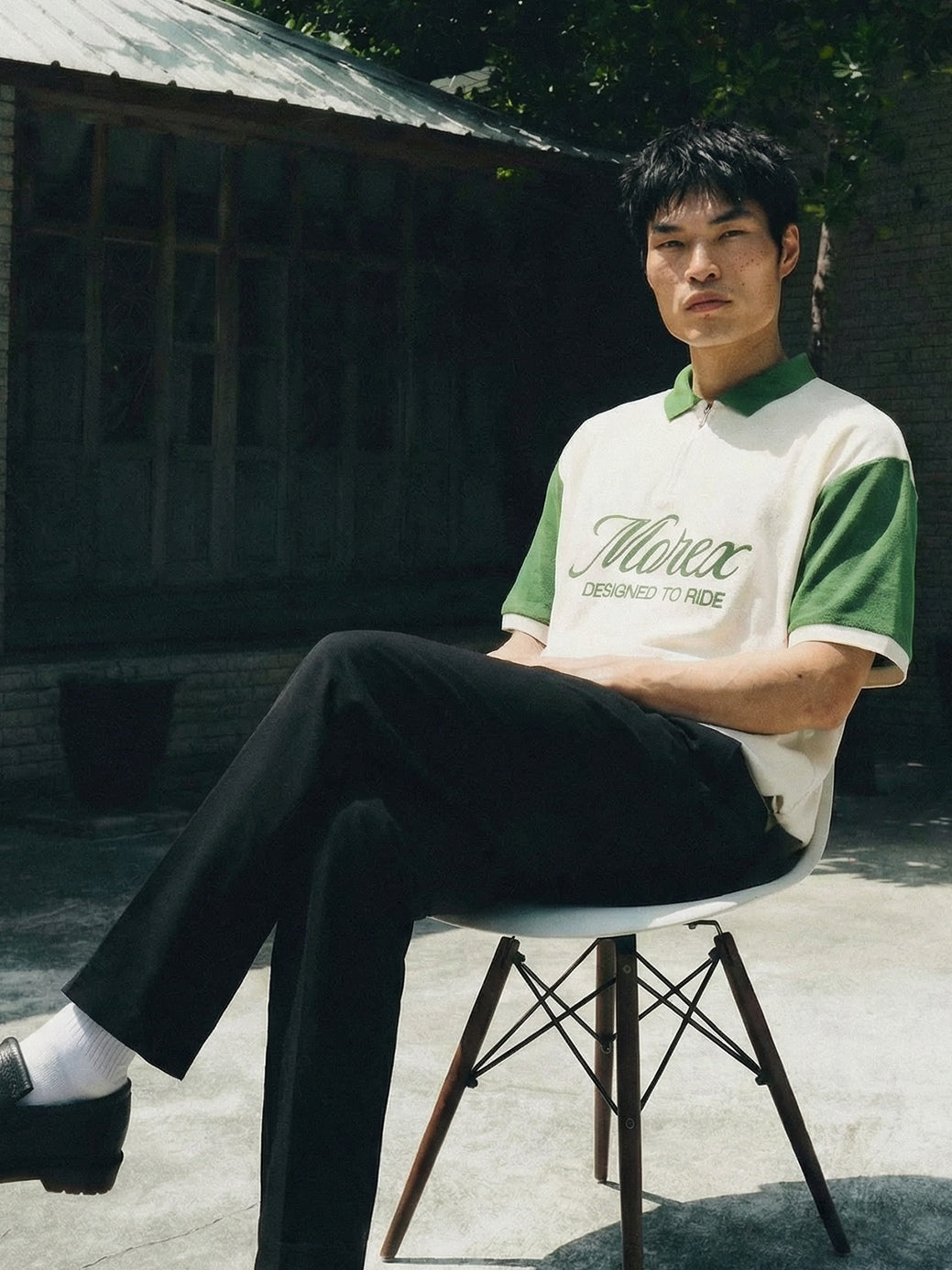 Polo Morex Custom bicolore blanc et vert pour homme porté avec un pantalon noir et des mocassins dans un cadre extérieur lifestyle.