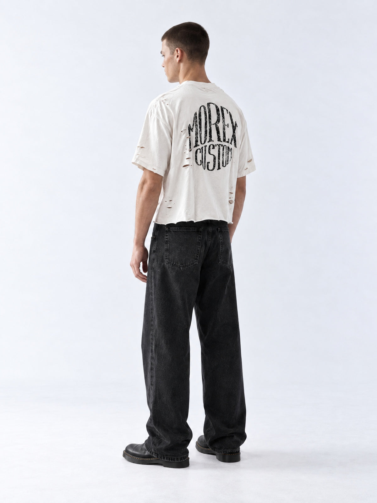 Vue de dos du t-shirt blanc cassé effet vieilli Morex Custom avec imprimé vintage au dos, porté avec un jean large noir délavé.