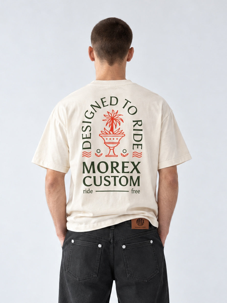 Vue arrière du t-shirt écru Morex Custom avec illustration graphique Designed to Ride, porté avec un pantalon loose noir style moto et streetwear.
