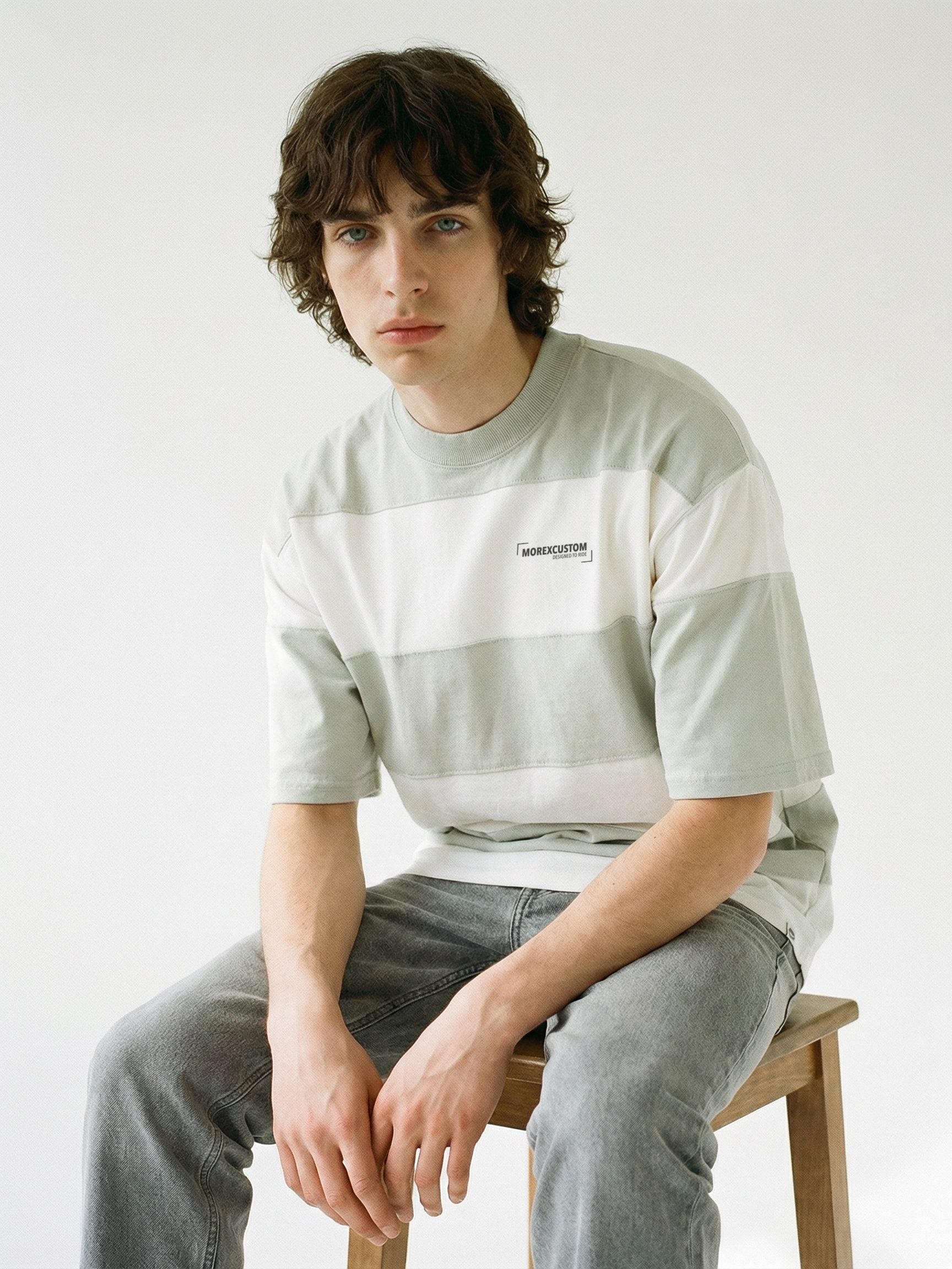Mannequin portant un t-shirt à larges rayures horizontales gris et blanc de la marque Morex Custom, associé à un jean gris.